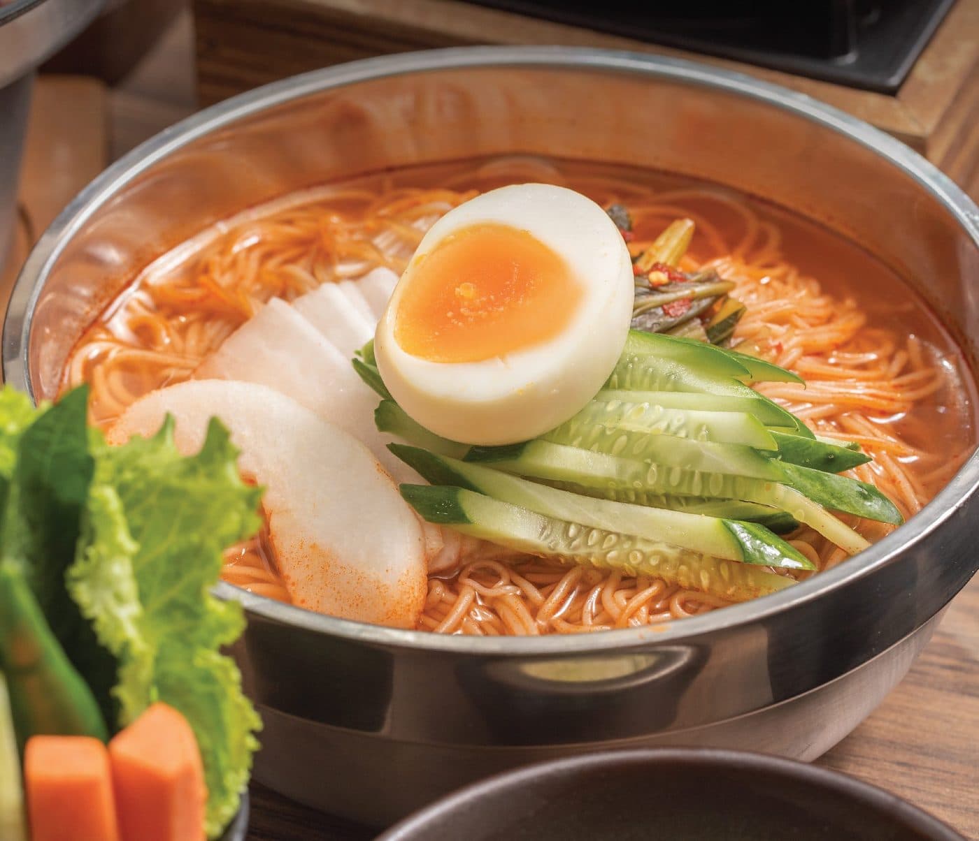 Spicy Korean noodles with a soft egg, served in the golden pot